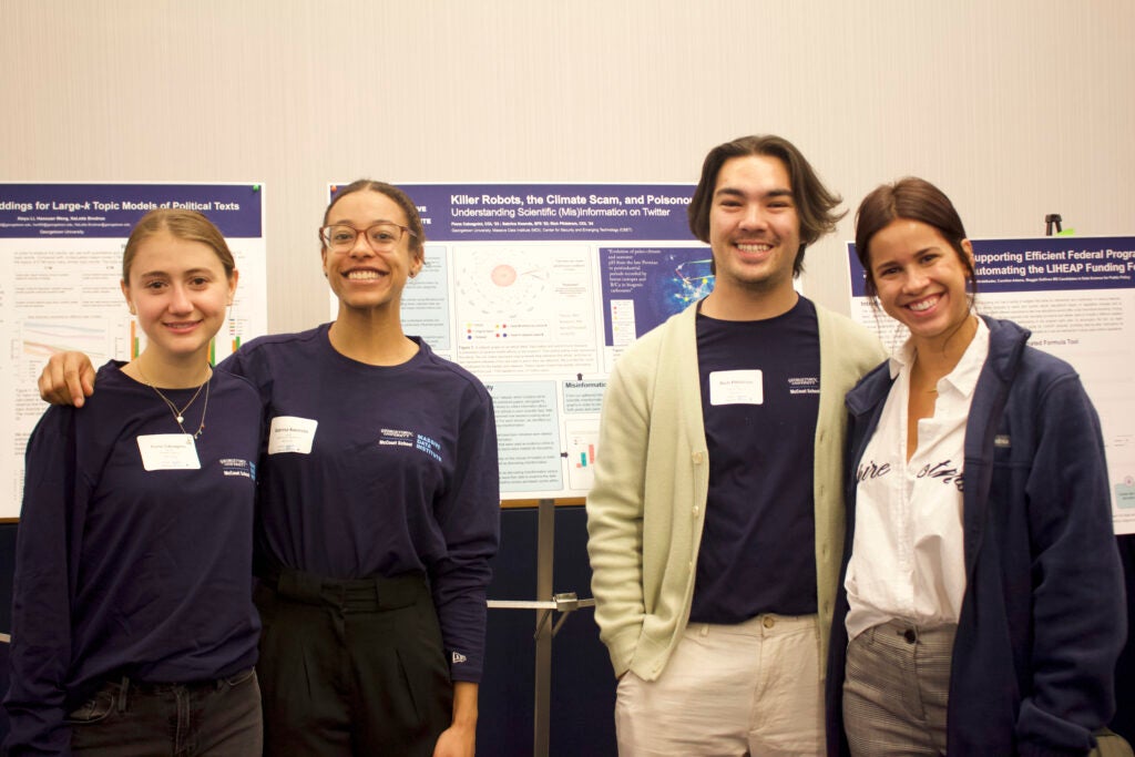 four people (Fiona, Sabrina, Rich, and Autumn) smiling in front of their poster
