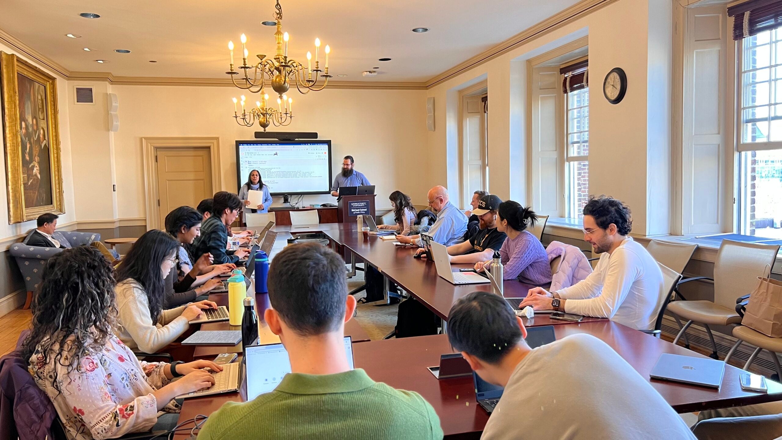 Photo of MDI Director and MDI Postdoc at the front of the room with workshop participants all around the room.